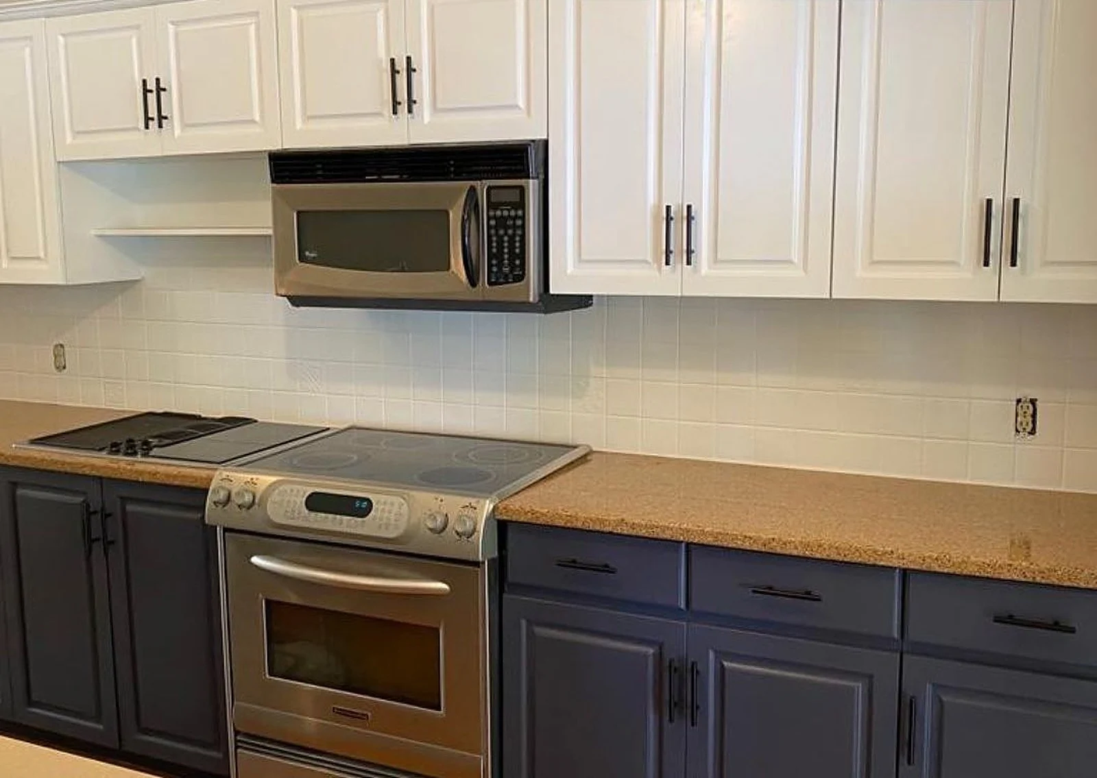 Kitchen with navy lower cabinets and white upper cabinets after spraying